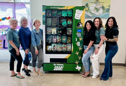Parent volunteers with a book vending machine