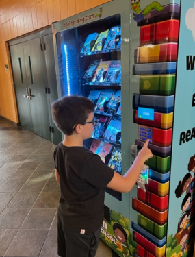 Student using Old Town Elementary School Book Vending Machine