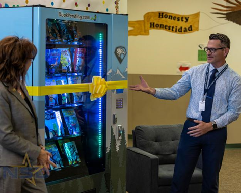 Superintendent Gregg Russell with Inchy's Book Vending Machine. Iowa Elementary, Nampa, Id.